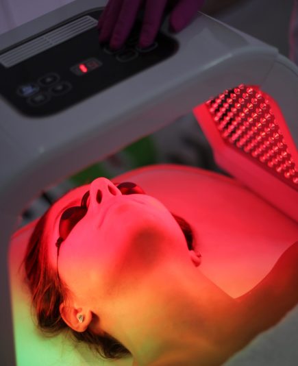 A young woman is having phototherapy in a beauty salon. Omega Light Therapy