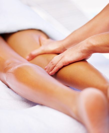 Closeup photo of a masseuse giving lady a leg massage